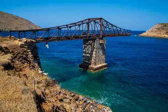 Hike along Serifos' trails and discover hidden gems, like the old bridge that leads to a mine in Megalo Livadi, a wonderful place to watch the sun set through the girders