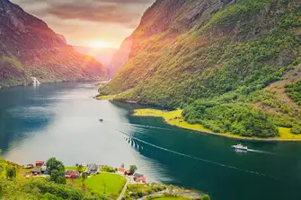 The green summer hillsides Norway's fjords dwarf visiting yachts